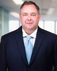 Profile picture of Stephen Pehrkon. Man stands in suit in office space