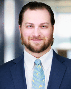 Headshot of Justin Schaffer with a blurred office background.